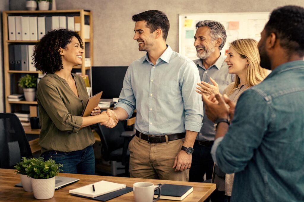 Equipo de personas de empresa dando la bienvenida a un nuevo empleado.