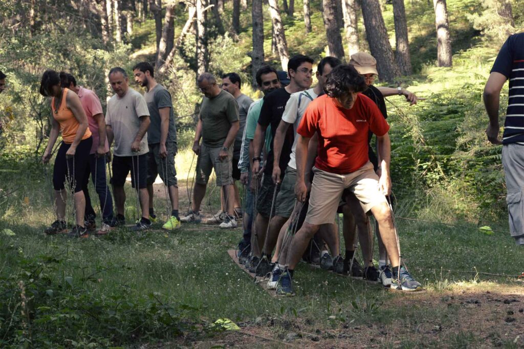 Equipo de personas afrontando desafíos en naturaleza y al aire libre. Están desarrollando un programa sobre inteligencia emocional.