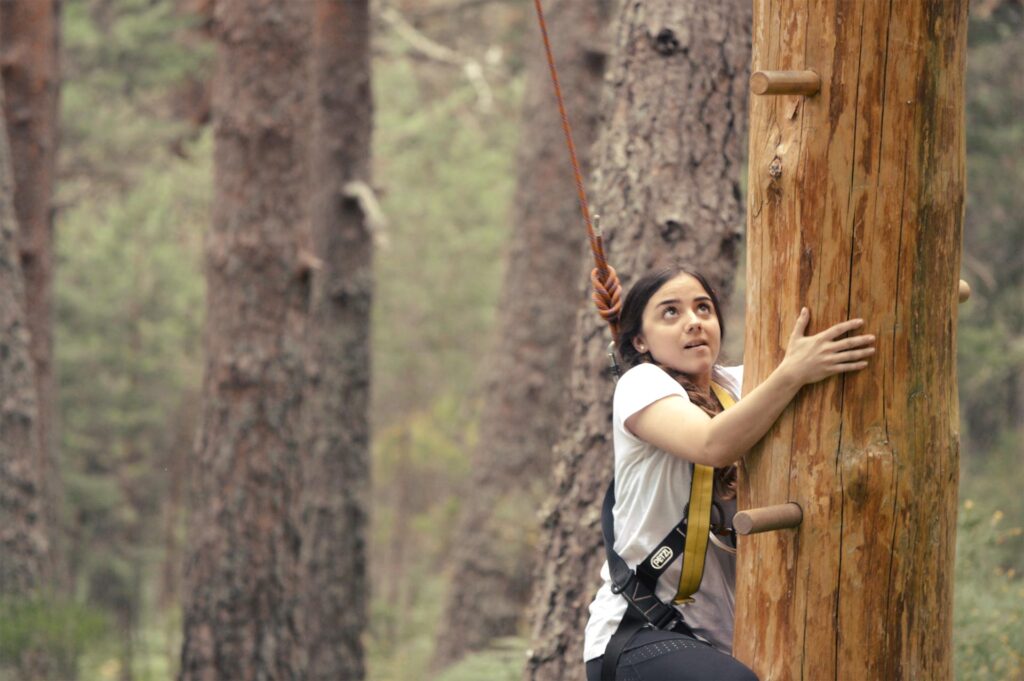 Miembro de equipo de trabajo de empresa desarrollando desafío en los árboles sobre inteligencia emocional en Amazonia Team Factory