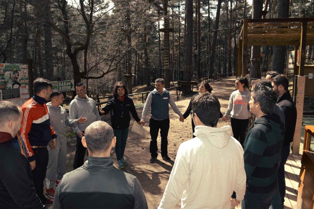 Grupo de personas de empresa formando rueda de comunicación en programa de Team Building para potenciar la escucha activa en Amazonia Team Factory