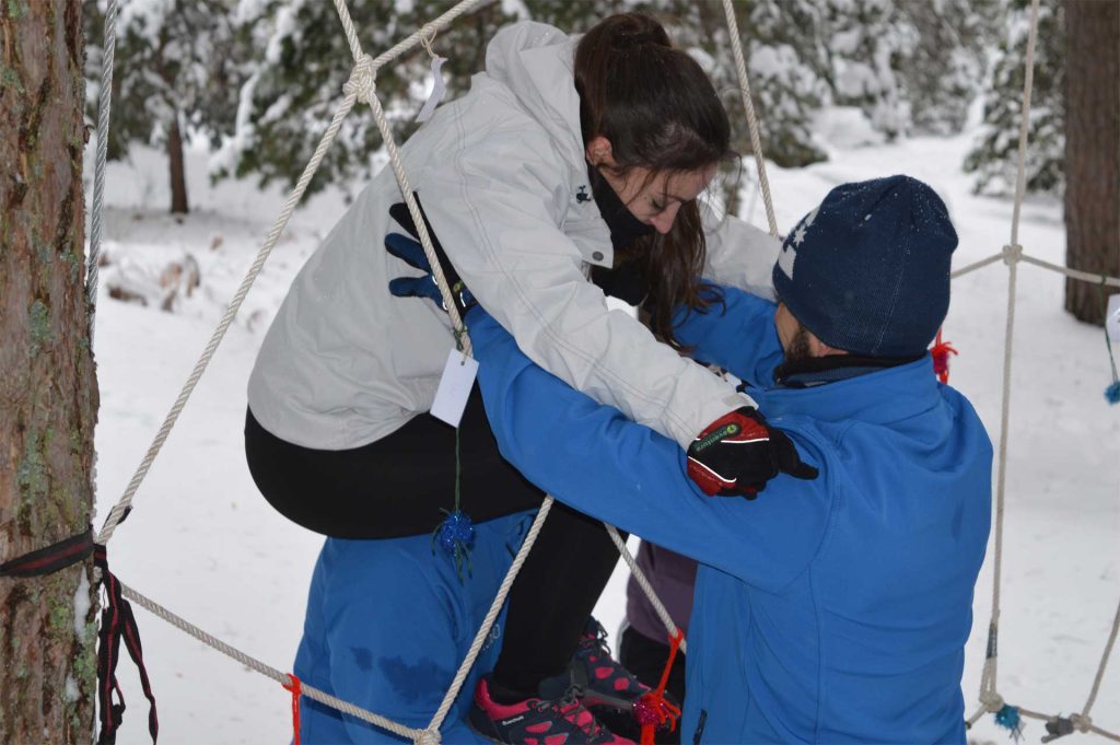 Participantes en actividad de Team Building en Amazonia Team Factory, ayudándose para superar desafío para personas resilientes.