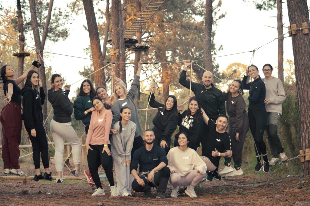 Equipo de empresa realizando actividades de Team Building al aire libre y en naturaleza. Han descubierto los beneficios de Team Building.