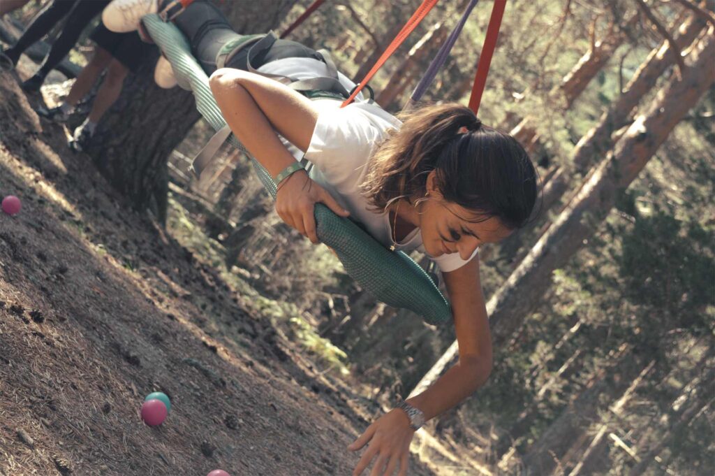 Participante de equipo de empresa realizando dinámica en programa de Team Building al aire libre y en naturaleza