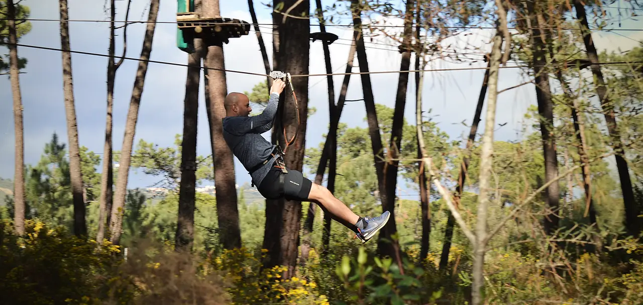 persona en tirolina en un evento de empresa en naturaleza